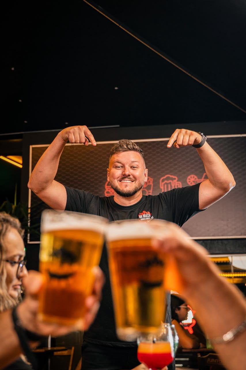 Cliente brindando com chopp no Beeis