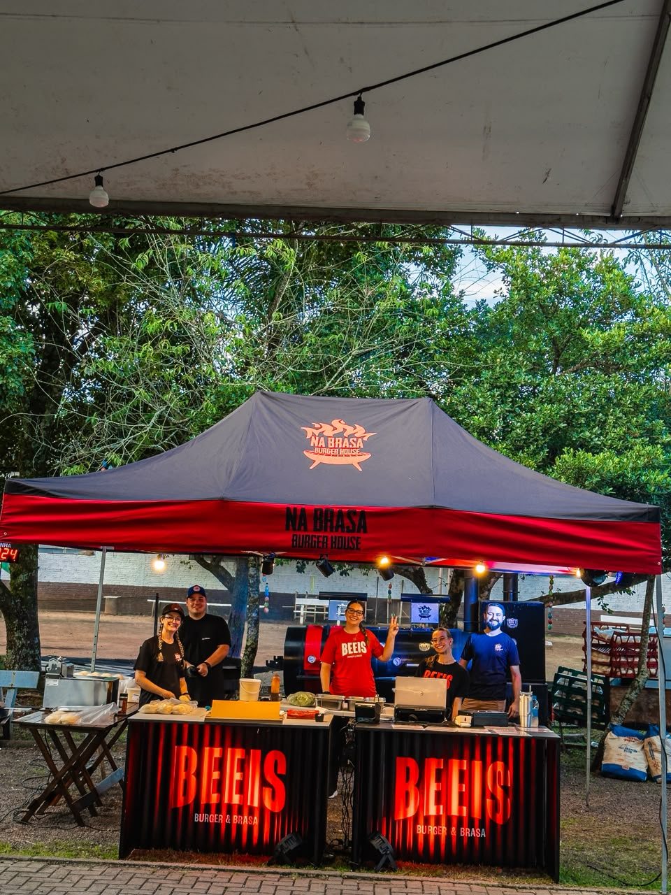 Equipe Beeis no estande de evento, sob tenda Na Brasa Burger House